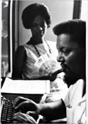 Rob Williams typing as Mabel Williams looks on