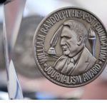 Photo of silver Hearst Journalism Award Medal suspended in glass.