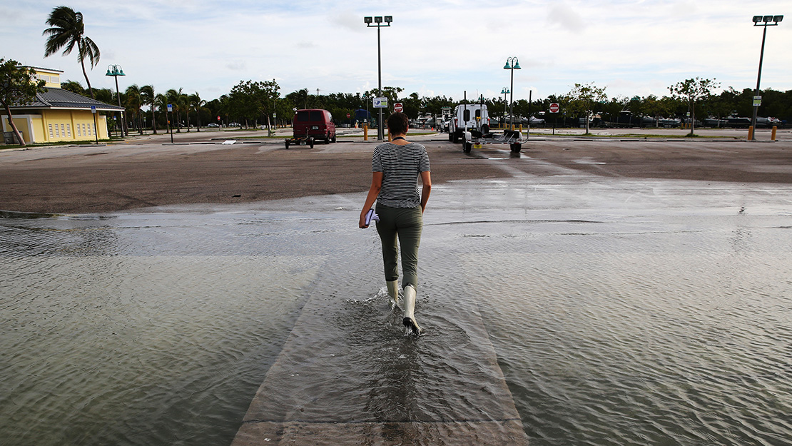 Alex Harris walks through a flooded parking lot.
