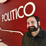Andrew Briz posing in front of Politico logo