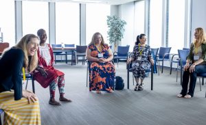 Facilitator Piper Hendricks shares a laugh with others during a session on wellness. Photo credit: Jenna Ayoub.