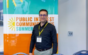 Nader Dagher, who helped organize the graduate student brainstorming session, stands in front of a summer institute banner. Photo credit: Jenna Ayoub.