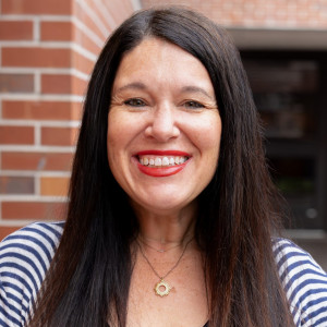 Erika Cooper Headshot in Weimer Hall Brick Wall Atrium
