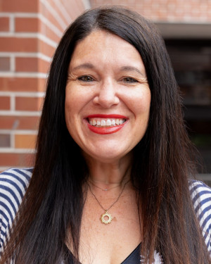 Erika Cooper Headshot in Weimer Hall Brick Wall Atrium