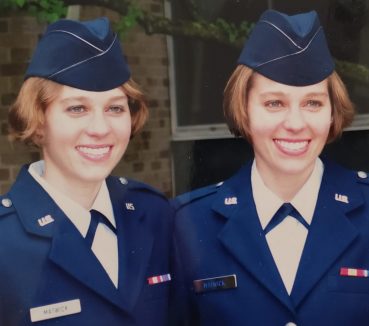 Keri and Kelsey Matwick dressed in navy-blue military uniforms.