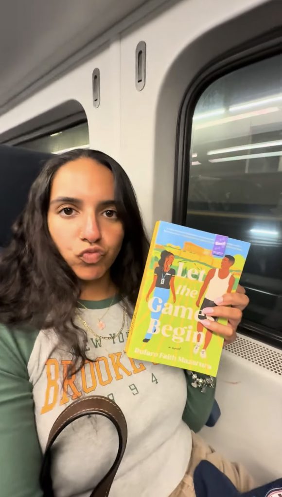 A close-up selfie of me during my commute with my current read beside me.