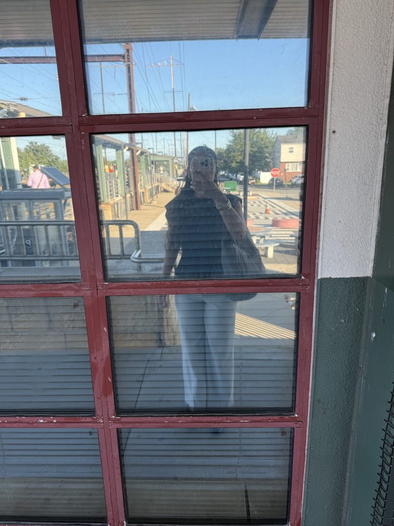 Yasmeen Hughes reflected in the glass of at the train station. 