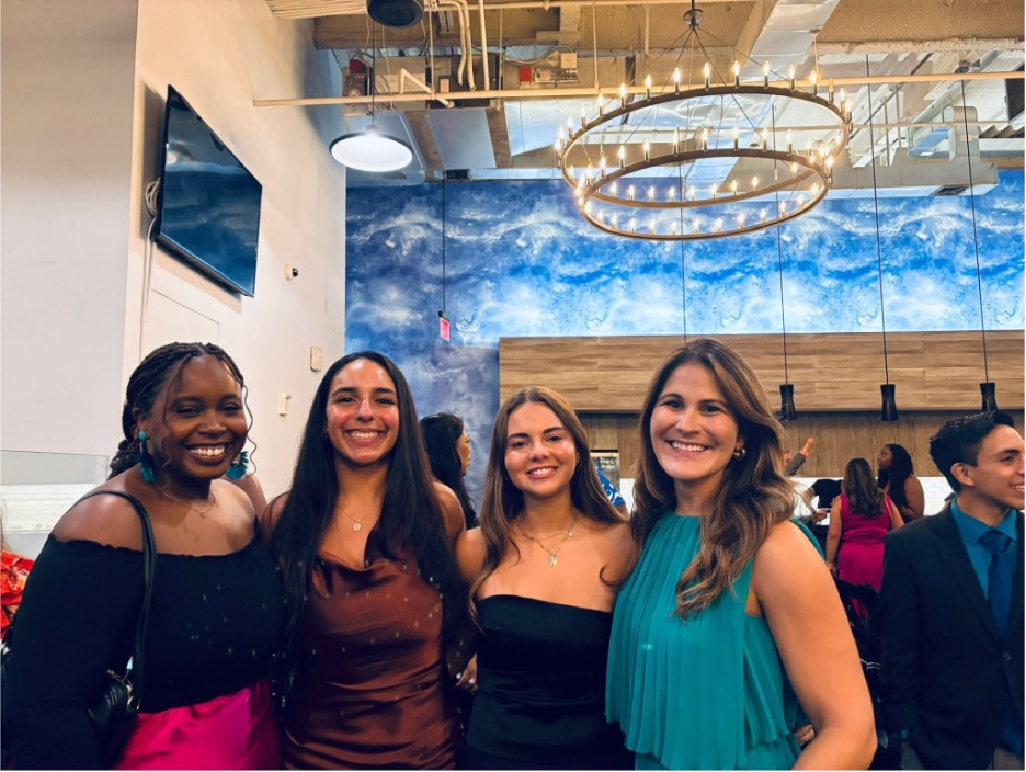 Group of four women standing together at an event. 
