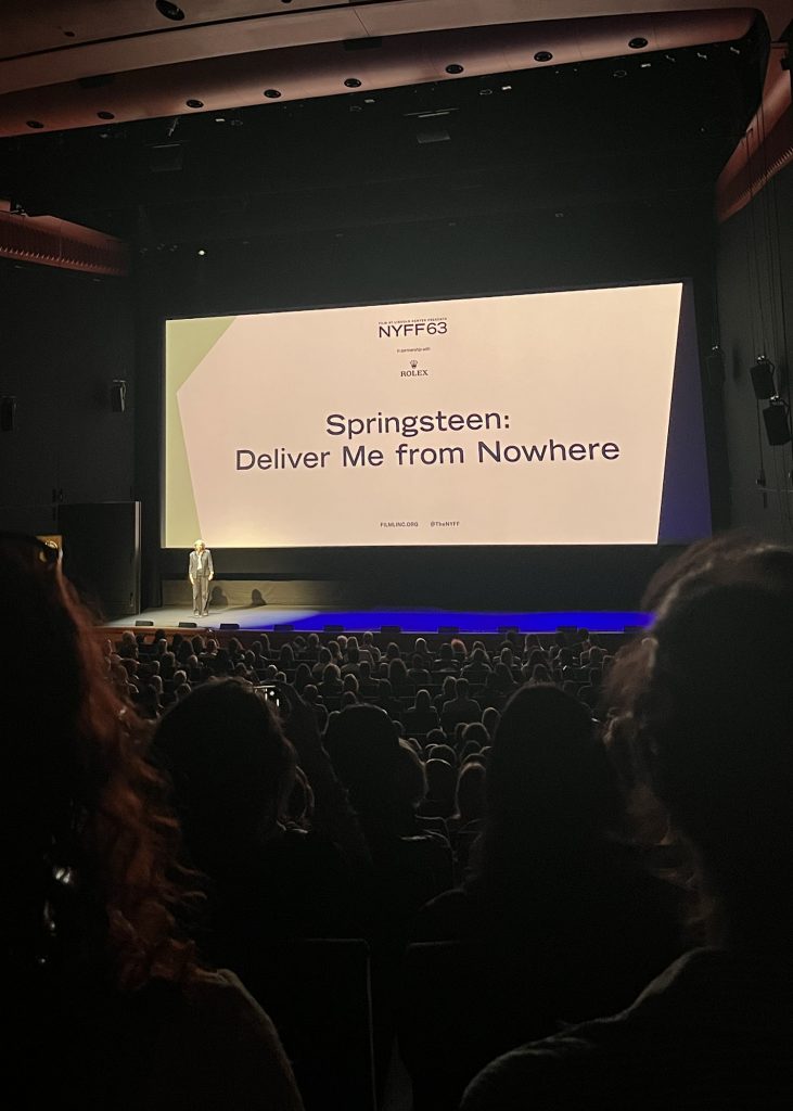 Dark theater scene with Springsteen biopic title slide on the screen.