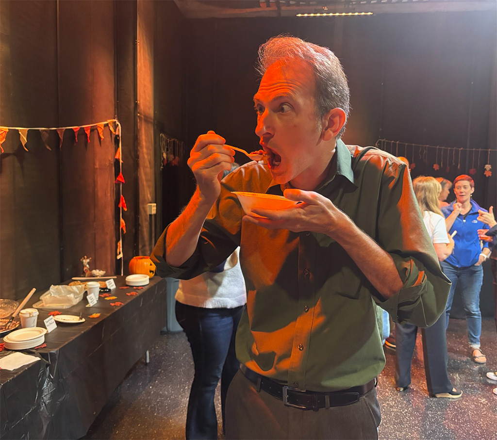 Faculty member eating a bowl of chili.
